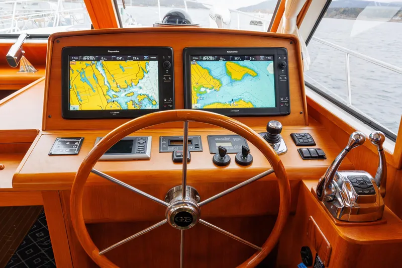Slide: The Image of Helm of 2014 Grand Banks 46 Eastbay SX with dual navigation screens and wooden steering wheel. - 42
