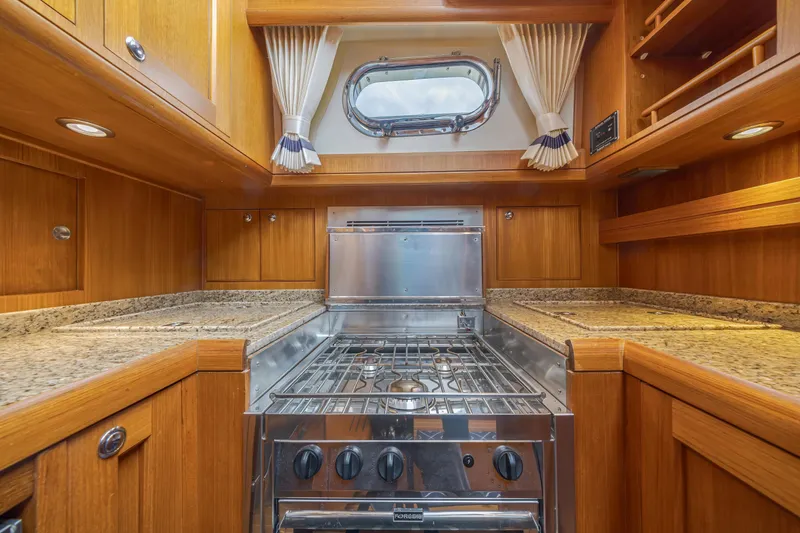 Slide: The Image of Luxurious 2014 Grand Banks 46 Eastbay SX yacht kitchen with wood cabinetry and stainless steel stove. - 46