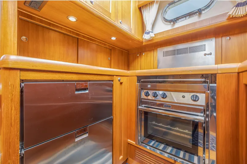 Slide: The Image of Luxurious 2014 Grand Banks 46 Eastbay SX yacht kitchen with stainless steel appliances and wood cabinetry. - 47
