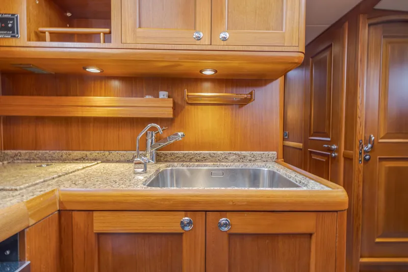 Slide: The Image of Luxurious wooden kitchen interior of 2014 Grand Banks 46 Eastbay SX yacht with granite countertops. - 48