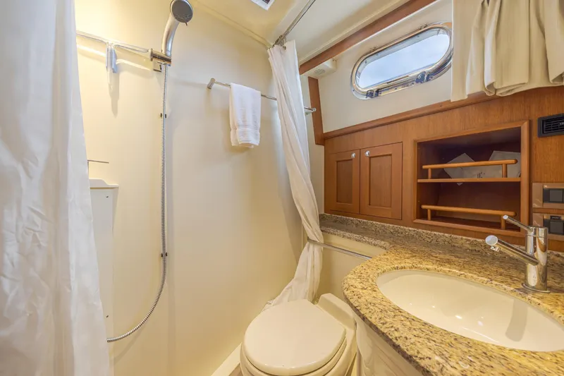 Slide: The Image of Luxurious bathroom in 2014 Grand Banks 46 Eastbay SX yacht with granite countertop and shower. - 52