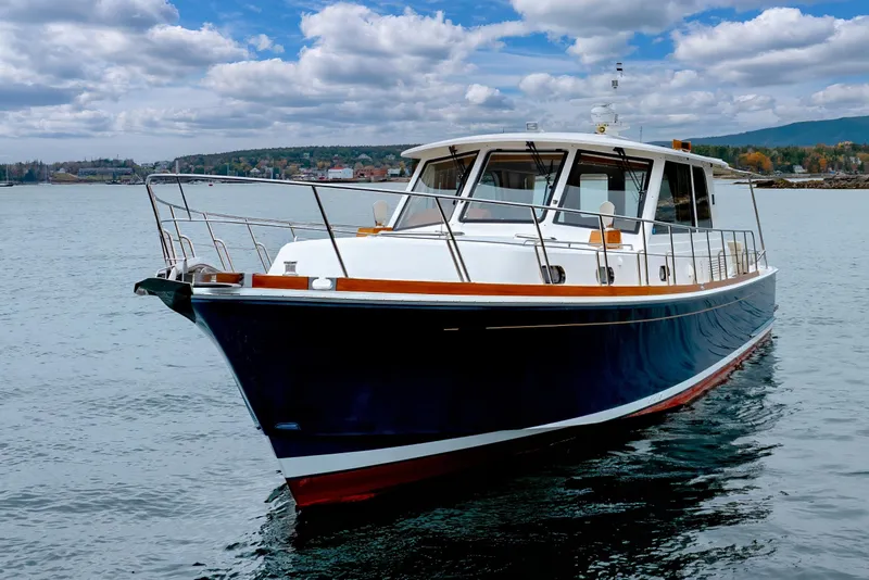 Slide: The Image of 2014 Grand Banks 46 Eastbay SX yacht on calm water under a cloudy sky. - 6