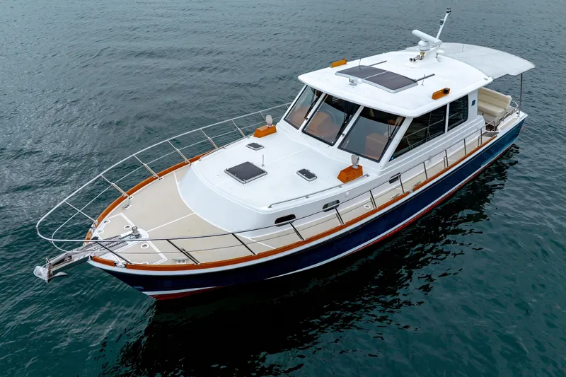 Slide: The Image of 2014 Grand Banks 46 Eastbay SX yacht on calm water, showcasing sleek design and spacious deck. - 9