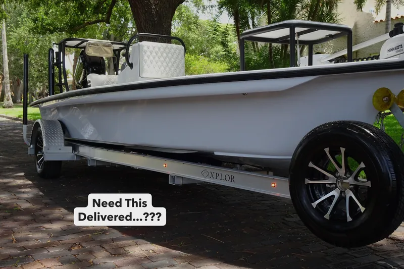 Slide: The Image of 2024 Xplor X18 Delta D18 boat on trailer, parked on a tree-lined street. - 3