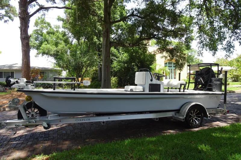 Slide: The Image of 2024 Xplor X18 Delta D18 boat on trailer, parked outdoors under trees. - 5