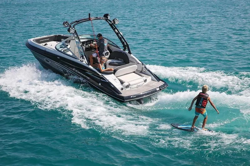Slide: The Image of 2019 Crownline 255 SS SURF boat with wakeboarder on turquoise water. - 6