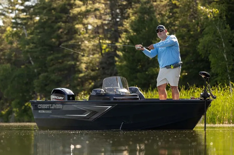Slide: The Image of Manufacturer Provided Image: Man fishing on 2026 Crestliner 1650 Kodiak SC boat in a serene lake setting. - 12
