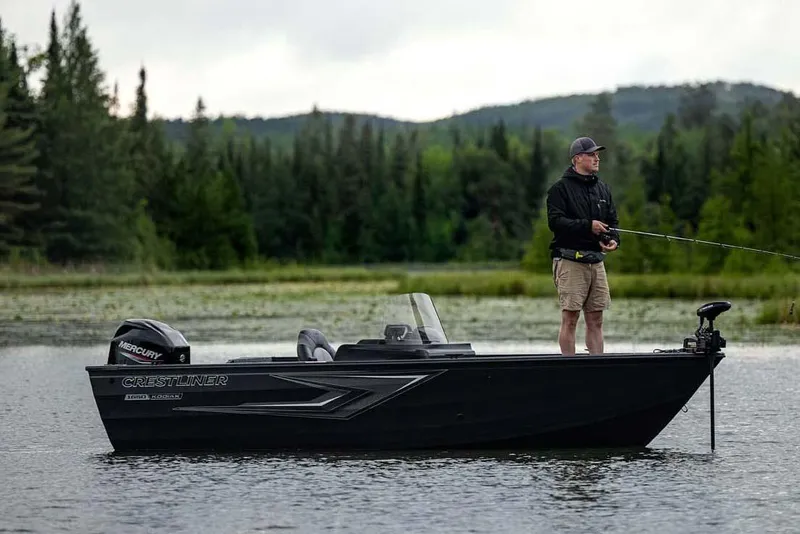 Slide: The Image of Manufacturer Provided Image: Man fishing on a 2026 Crestliner 1650 Kodiak SC boat in a serene lake setting. - 13