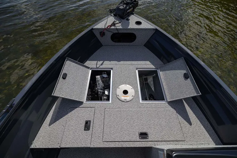 Slide: The Image of Manufacturer Provided Image: 2026 Crestliner 1650 Kodiak SC boat deck with open storage compartments on the water. - 14