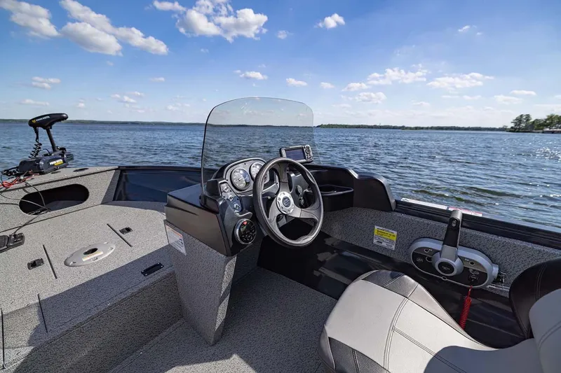 Slide: The Image of Manufacturer Provided Image: 2026 Crestliner 1650 Kodiak SC boat interior with steering wheel, dashboard, and lake view. - 16