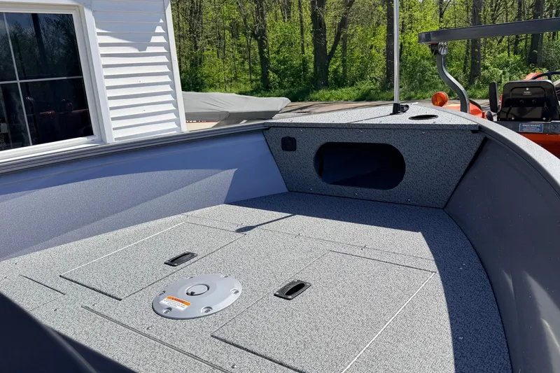 Slide: The Image of 2026 Crestliner 1650 Kodiak SC boat interior with storage compartments, outdoors. - 6