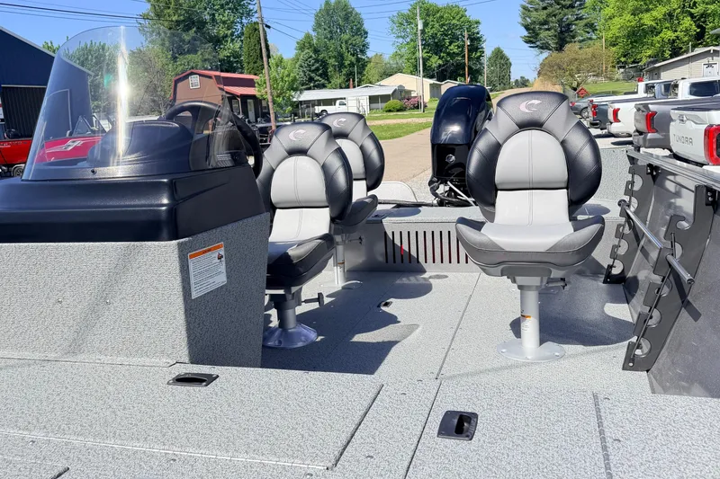 Slide: The Image of 2026 Crestliner 1650 Kodiak SC boat interior with seating and console, parked outdoors. - 7