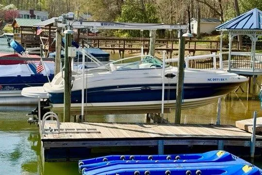 Slide: The Image of 2008 Sea Ray 240 Sundeck boat docked at a marina with surrounding watercraft. - 2