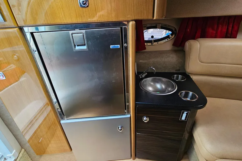 Slide: The Image of 2013 Formula 310 FX5 interior with compact kitchenette, stainless steel fridge, and sink. - 26