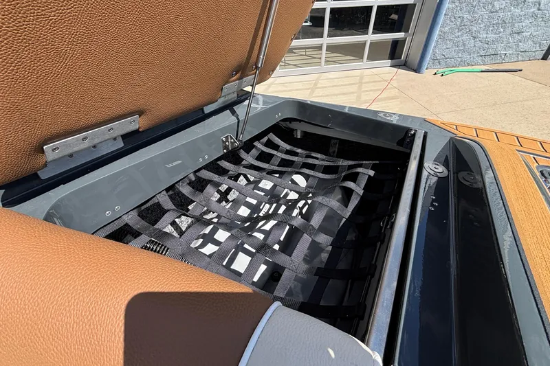 Slide: The Image of Open storage compartment in 2026 MB B52 23 Alpha boat with brown upholstery. - 15