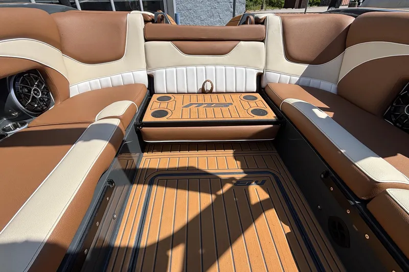 Slide: The Image of 2026 MB B52 23 Alpha boat interior with brown and cream seating, cup holders, and teak flooring. - 21
