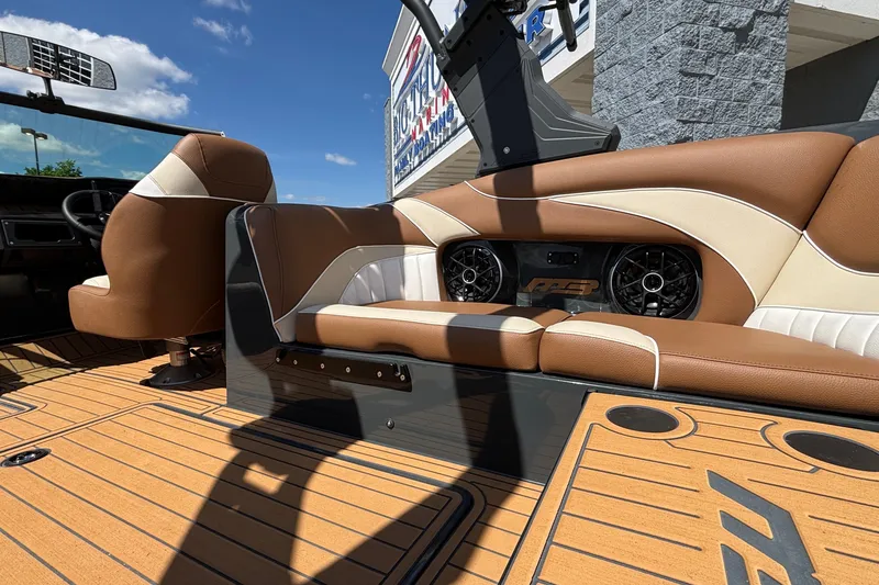 Slide: The Image of 2026 MB B52 23 Alpha boat interior with brown and white seating, speakers, and wood flooring. - 25