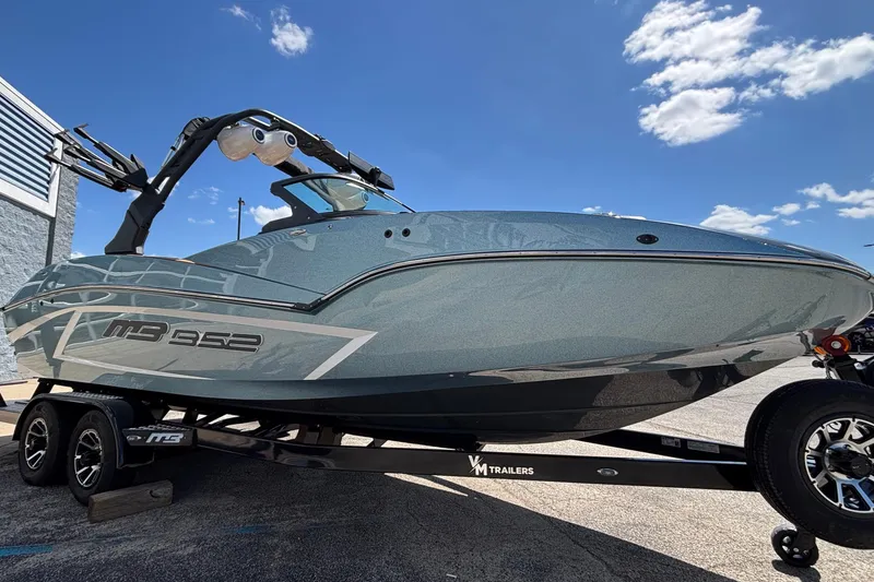 Slide: The Image of 2026 MB B52 23 Alpha boat on trailer under clear blue sky. - 3