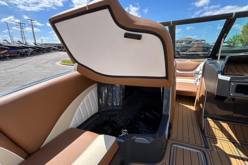 Slide: The Image of 2026 MB B52 23 Alpha boat interior with open storage compartment, brown and white seating. - 34