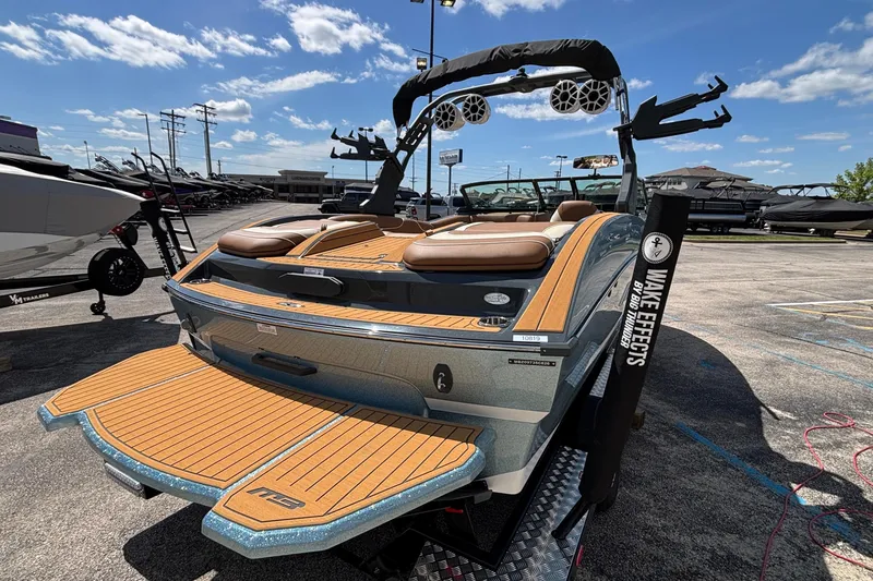 Slide: The Image of 2026 MB B52 23 Alpha boat with teak deck, parked outdoors under blue sky. - 5