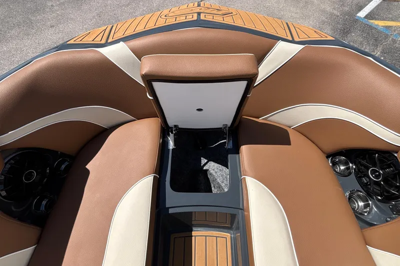 Slide: The Image of 2026 MB B52 23 Alpha boat interior with brown and cream seating, featuring cup holders. - 55