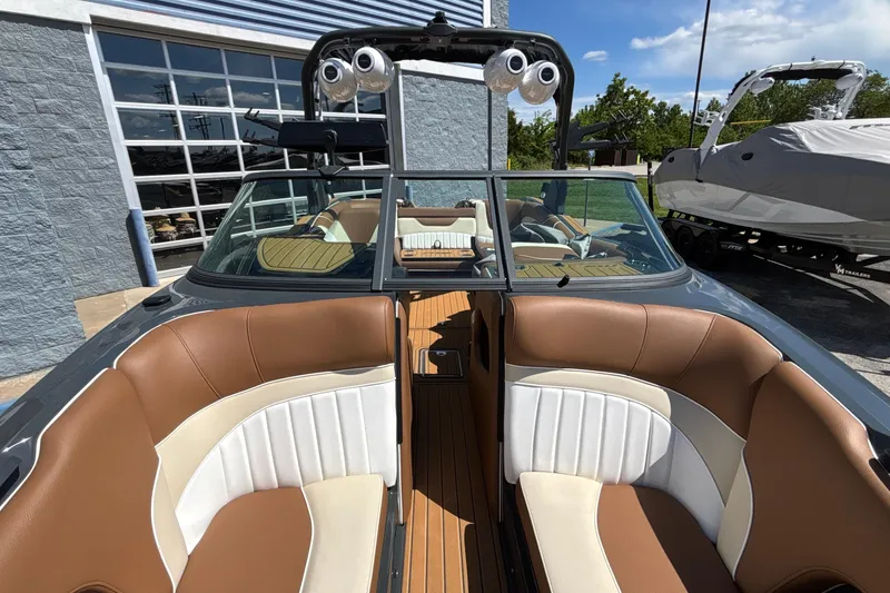 Slide: The Image of 2026 MB B52 23 Alpha boat interior with brown and white seating, docked outdoors. - 58