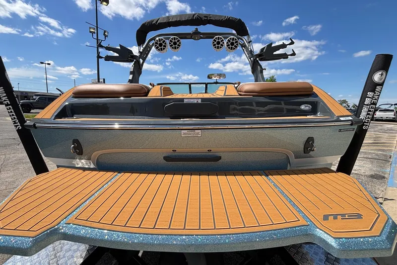 Slide: The Image of 2026 MB B52 23 Alpha boat with teak deck and wakeboard tower under blue sky. - 8