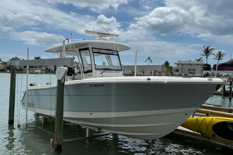 The Image of 2022 Robalo R302 Center Console boat docked at marina under cloudy sky. - 0
