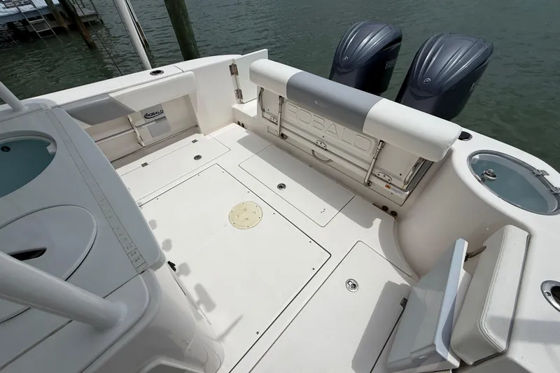 Slide: The Image of 2022 Robalo R302 Center Console boat deck with twin engines and seating. - 12