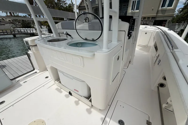 Slide: The Image of 2022 Robalo R302 Center Console boat interior with sink and storage compartments. - 13
