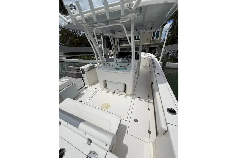 Slide: The Image of 2022 Robalo R302 Center Console boat interior with seating and console, docked by water. - 17