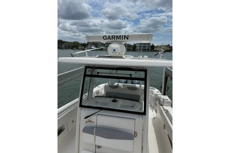 Slide: The Image of 2022 Robalo R302 Center Console boat with Garmin radar, docked by waterfront homes. - 7