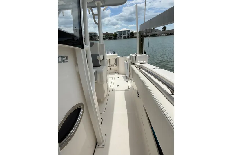 Slide: The Image of 2022 Robalo R302 Center Console boat docked by waterfront homes. - 8