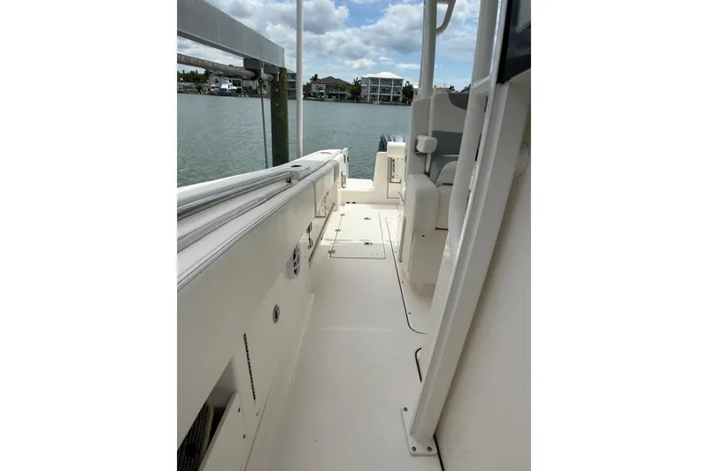 Slide: The Image of 2022 Robalo R302 Center Console boat interior with seating, docked by the water. - 9