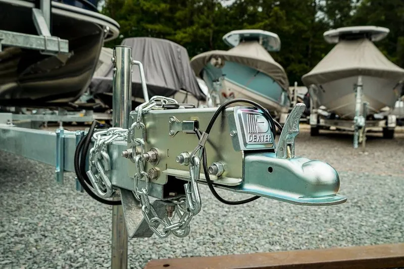 Slide: The Image of Trailer hitch close-up with boats in background, featuring Trifecta LE 22RF, 2026 model. - 44