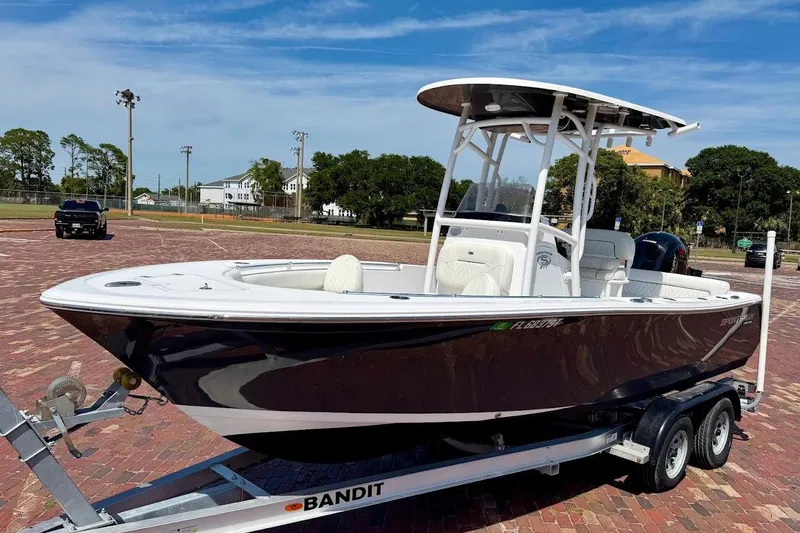 The Image of 2020 Sportsman Heritage 211 Center Console boat on trailer in sunny parking lot. - 1