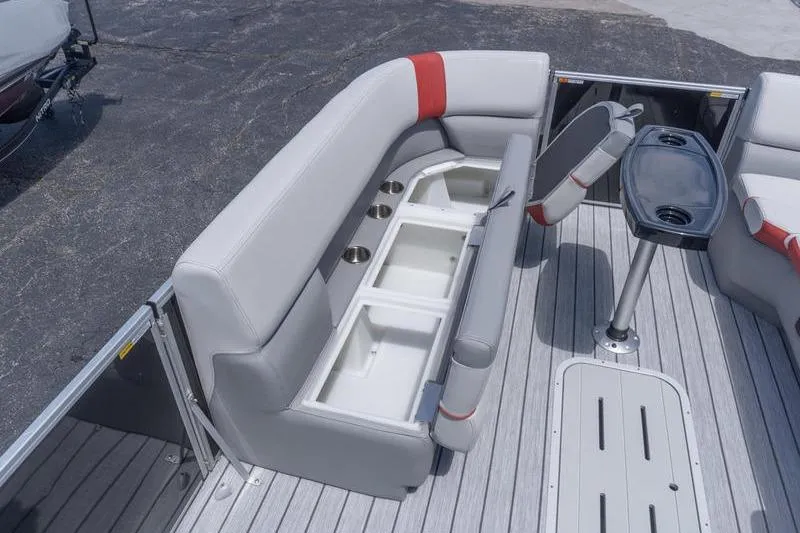 Slide: The Image of 2026 SunCatcher Select 322SL boat interior with gray seating, storage compartments, and a table. - 17