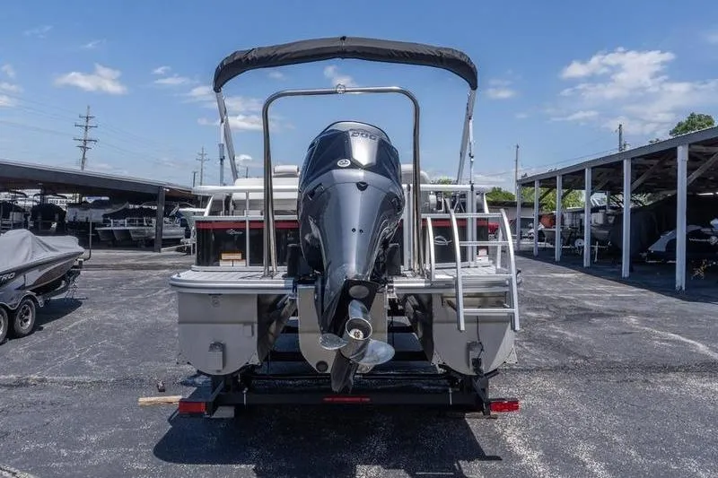 Slide: The Image of 2026 SunCatcher Select 322SL pontoon boat with outboard motor, parked in a marina. - 2