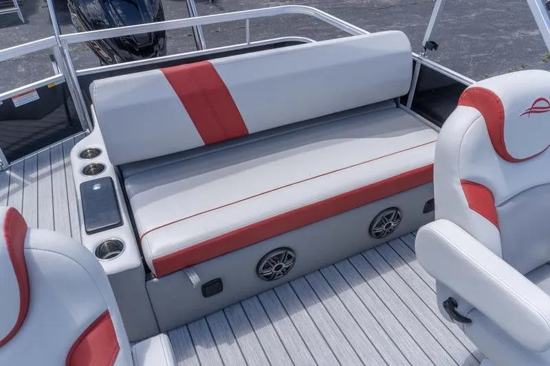 Slide: The Image of 2026 SunCatcher Select 322SL boat interior with gray and red seating, cup holders, and speakers. - 22