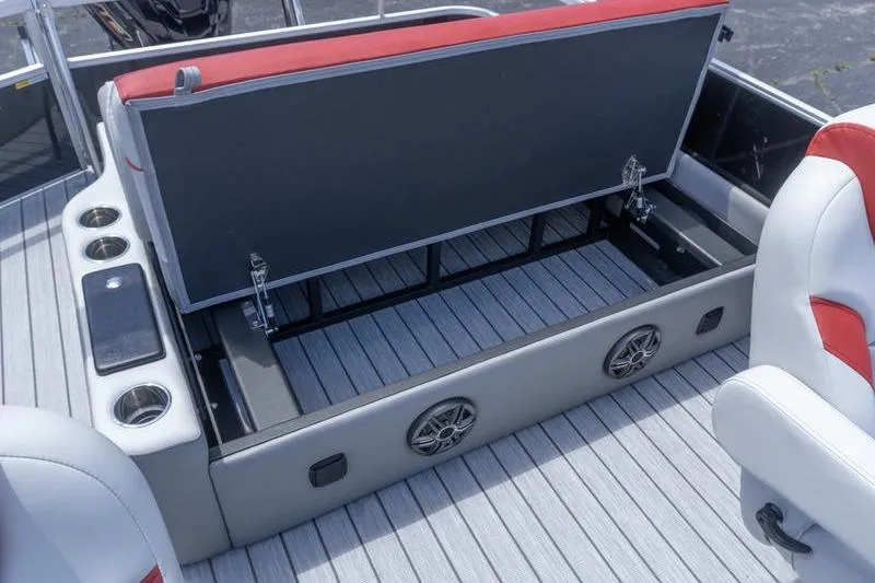 Slide: The Image of 2026 SunCatcher Select 322SL boat interior with open storage compartment and cup holders. - 23