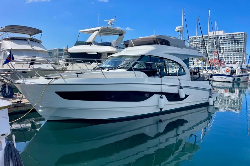 The Image of 2023 Beneteau Antares 11 Fly yacht docked in marina, reflecting on calm water. - 0