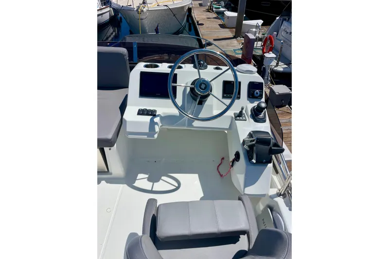 Slide: The Image of 2023 Beneteau Antares 11 Fly helm with modern controls and steering wheel at dock. - 10