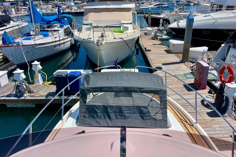 Slide: The Image of 2023 Beneteau Antares 11 Fly docked at a marina, surrounded by other boats. - 12