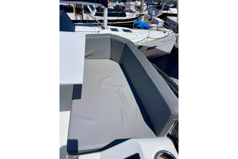 Slide: The Image of 2023 Beneteau Antares 11 Fly boat with gray cushioned seating area. - 13