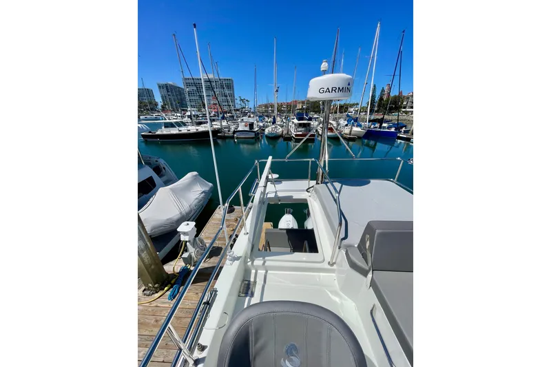 Slide: The Image of 2023 Beneteau Antares 11 Fly at marina, surrounded by boats and clear blue sky. - 14