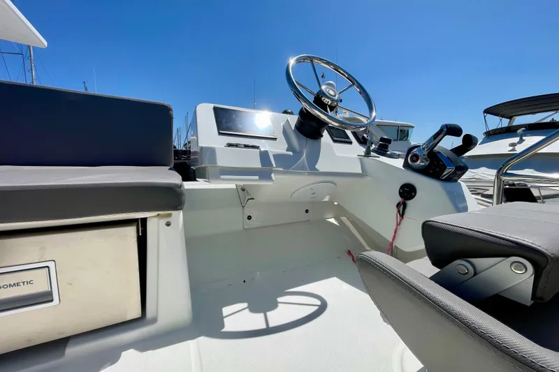 Slide: The Image of 2023 Beneteau Antares 11 Fly helm with modern controls and seating under clear blue sky. - 15