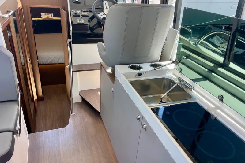Slide: The Image of Interior of 2023 Beneteau Antares 11 Fly, featuring helm, kitchenette, and cabin entrance. - 20