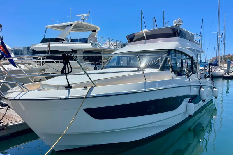 Slide: The Image of 2023 Beneteau Antares 11 Fly yacht docked in a marina under clear blue skies. - 33