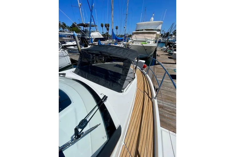 Slide: The Image of 2023 Beneteau Antares 11 Fly yacht docked at marina, showcasing sleek design and wooden deck. - 5