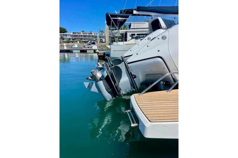 Slide: The Image of 2023 Beneteau Antares 11 Fly boat docked, showcasing outboard motor and swim platform. - 9